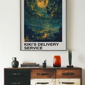 May include: A poster with a dark blue background featuring a girl flying in front of a full moon and a city with twinkling lights. The poster has the text "Studio Ghibli" and "Kiki's Delivery Service" in white lettering.