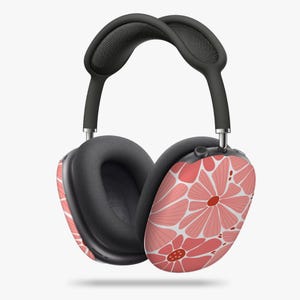 Puede incluir: Auriculares supraaurales con un diseño floral. Los auriculares presentan un patrón de flores rosas con detalles blancos. La diadema y las almohadillas son negras.
