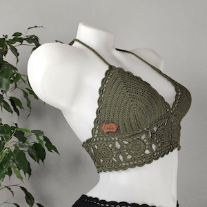 Puede incluir: Un top de bikini de crochet verde con una etiqueta marrón que dice "Orlena" y una parte inferior de bikini de crochet negro.