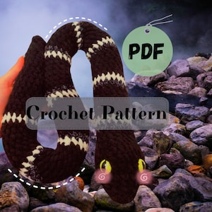 Op de afbeelding: Een haakpatroon voor een bruin-wit gestreepte slang met gele ogen. Het patroon is beschikbaar als PDF-download. Haakpatroon.