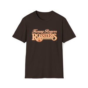 Könnte beinhalten: Ein braunes T-Shirt mit dem Kenny Rogers Roasters Logo auf der Vorderseite. Das Logo zeigt eine Flamme und den Text "Kenny Rogers Roasters" und "Deliciously Healthy".