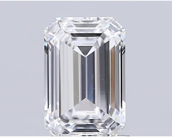 May include: A clear, emerald-cut diamond with a rectangular shape and faceted surfaces. The facets reflect light, creating a brilliant sparkle. The gemstone is set against a neutral background, highlighting its clarity and brilliance.