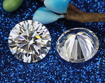 May include: Two round, brilliant-cut diamonds. The diamonds are clear and faceted, reflecting light. The background is a dark blue, glittery surface with decorative elements.