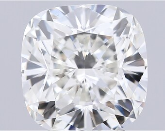 May include: A close-up of a cushion-cut diamond. The diamond is clear and colorless, with numerous facets that reflect light. The shape is square with rounded corners, and the overall appearance is brilliant and sparkling. The diamond is set against a light gray background.