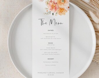 May include: A white menu card with floral accents and the text "The Menu" in elegant script. The menu lists entrees, mains, and dessert options. The card is placed on a white plate, with dried flowers in the background.