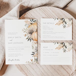 Pode incluir: Conjunto de convites de casamento com um convite principal, um cartão de detalhes e um cartão RSVP. O design inclui ilustrações florais e de abóboras em tons suaves. O texto inclui os nomes Emily Smith e Sam Johnson, juntamente com detalhes do casamento.