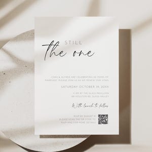 May include: A simple wedding invitation with the words "Still the One" in cursive. The invitation includes details about a vow renewal ceremony, date, and location. The invitation is on a white background with a shadow.
