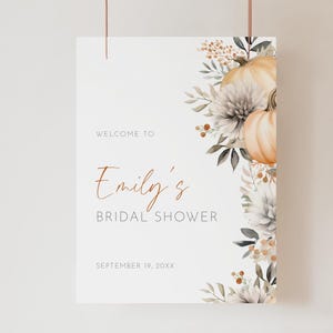 Pode incluir: Uma placa branca com o texto "Welcome to Emily's Bridal Shower" em escrita elegante. A placa é decorada com abóboras, flores e folhagens em aquarela em tons de laranja, cinza e verde. A data "September 19, 20XX" também está incluída.