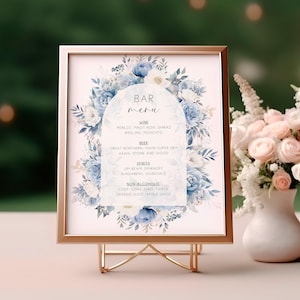 May include: A printable wedding bar menu sign with a watercolor floral design in shades of blue and white. The sign lists the drinks available at the bar, including wine, beer, spirits, and non-alcoholic options.