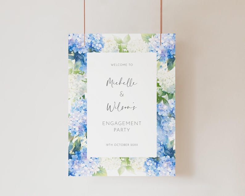 May include: A rectangular engagement party sign with a floral border of blue and white hydrangeas. The sign reads "Welcome to Michelle & Wilson's Engagement Party" with the date "19th October 20XX" at the bottom.