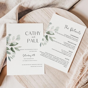 Op de afbeelding: Twee trouwuitnodigingskaarten met accenten van eucalyptusbladeren. De kaarten zijn wit met zwarte tekst, waaronder de namen "Cathy en Paul" en "Zaterdag 19". Details van de ceremonie en receptie zijn ook afgedrukt.