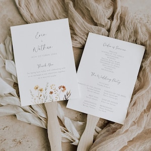 Puede incluir: Dos programas de abanico de boda con mangos de madera. Un abanico presenta los nombres "Erin & Nathan" y la fecha "19 de octubre de 30XX", con detalles florales. El otro abanico enumera el "Orden de la ceremonia" y "El séquito nupcial".