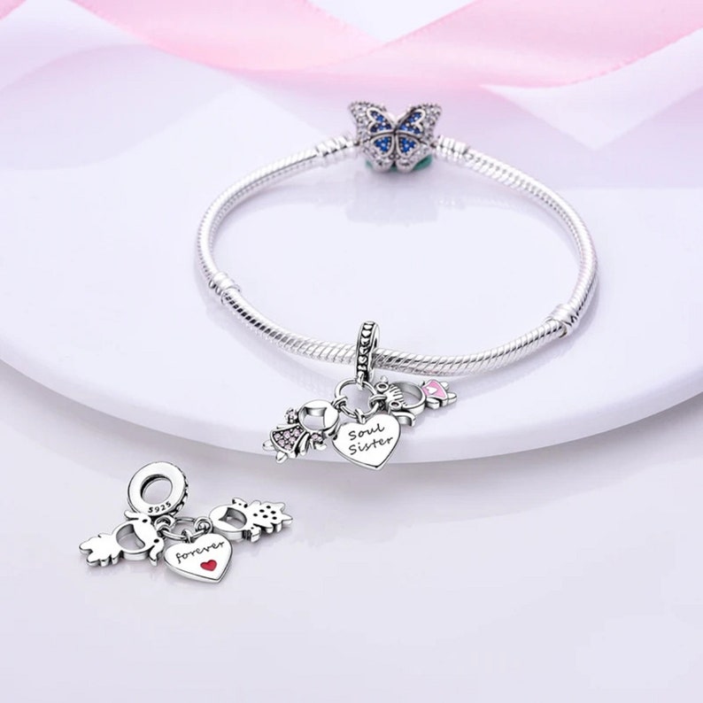 May include: Silver charm bracelet with a butterfly charm, a heart charm that says "Soul Sister", and a charm with a heart that says "forever" and two small charms.