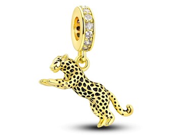 May include: Gold-toned charm featuring a detailed cheetah figurine with black spots. The charm has a round, clear crystal-encrusted ring at the top.