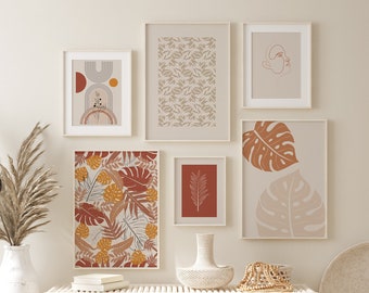 May include: A white wooden bench with two white wicker baskets underneath. The bench is decorated with a variety of framed prints featuring abstract designs and tropical leaves in shades of brown, orange, and beige.