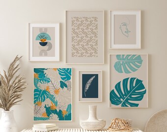 May include: A gallery wall featuring framed art prints with botanical and abstract designs. The prints showcase teal, orange, and beige tropical leaves, abstract shapes, and a line drawing of a face. The frames are light-colored, and the overall aesthetic is modern.