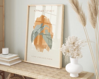 May include: A framed print with a nature-inspired design. The print features a stylized illustration of leaves in shades of green and brown on a light orange background. The text "NATURE SPIRIT" and "LEAF COLLECTION" is printed on the print.