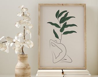 May include: A framed print with a line drawing of a person sitting with a leafy branch growing from their head. The print has a light beige background and a wooden frame.