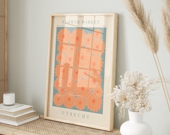 May include: A framed art print featuring a floral design with the text "FLOWER MARKET" and "UTRECHT". The artwork showcases orange flowers against a teal background. The print is in a light-colored wooden frame, suitable for home decor.