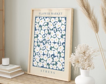 May include: A framed print with a blue background and white flowers. The print says "FLOWER MARKET" and "ATHENS" at the top and bottom.