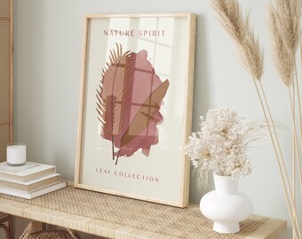 May include: A framed print with a watercolor-style illustration of two brown leaves on a pink background. The print has the text "NATURE SPIRIT" and "LEAF COLLECTION" in a sans-serif font.