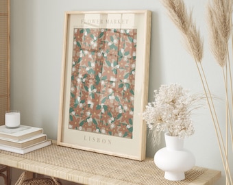 May include: A framed print with a floral pattern in shades of pink, green, and white. The print has the text "FLOWER MARKET" and "LISBON" on it.