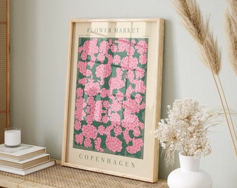 May include: A framed poster with a floral design. The poster features pink flowers on a green background. The text "FLOWER MARKET" and "COPENHAGEN" are printed on the poster.