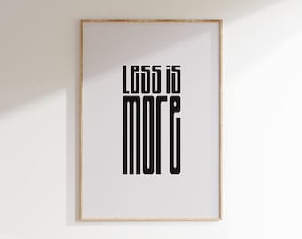 May include: A framed print with the text "Less is More" in a bold, blocky font. The print is on a white background and has a light wood frame.