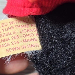 May include: A yellow tag with black text that reads "FILLED WITH ALL NEW POLYURETHANE FO MATERIALS - LICENS PENNA 268 - OHIO 6 MASS 214 - MAINE SEWN IN HAITI"