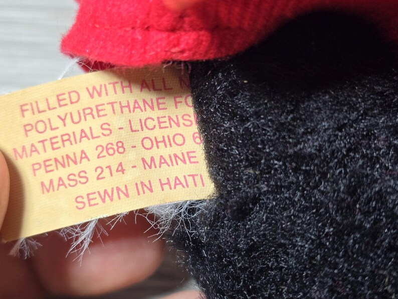 May include: A yellow tag with black text that reads "FILLED WITH ALL NEW POLYURETHANE FO MATERIALS - LICENS PENNA 268 - OHIO 6 MASS 214 - MAINE SEWN IN HAITI"