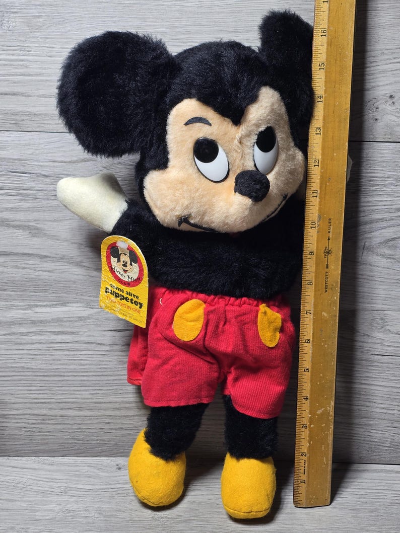 May include: A vintage plush Mickey Mouse toy with black fur, red shorts, yellow shoes, and a tag that reads "Come alive Puppet toy".