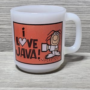 May include: White ceramic mug with a red and orange graphic. The graphic features a cartoon character holding a cup and the text "I LOVE JAVA!"
