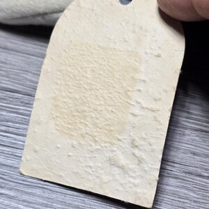 May include: A blank white tag with a hole punched in the top. The tag is attached to a black and white stuffed animal.