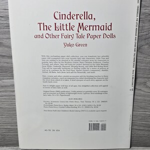 May include: A paperback book titled "Cinderella, The Little Mermaid and Other Fairy Tale Paper Dolls" by Yuko Green. The cover has a maroon title on a white background. The book contains paper dolls and costumes from various fairy tales.