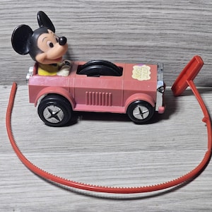 Op de afbeelding: Een witte keramische mok met een zwart handvat en de tekst "But First, Coffee" in een zwarte, handgeschreven lettertype. De mok staat op een wit oppervlak.