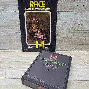 May include: A black Sears Tele-Games cartridge for the game "Race: Auto Racing" for 1 or 2 players. The cartridge is labeled with the game title, "Tele-Games", and "Race". The cartridge is also labeled with the number "14" and "99821".