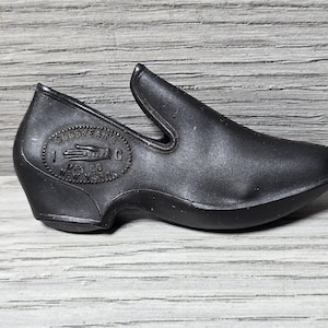 May include: Black rubber overshoe with a Goodyear label and the text "Mfg. Co. New York" on the side.