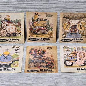 Op de afbeelding: Een set van tien verzamelkaarten met cartoonillustraties van verschillende personages en voertuigen. De kaarten zijn allemaal in een vergelijkbare stijl, met een witte achtergrond en een kleurrijk cartoonbeeld. De kaarten zijn allemaal gelabeld met de naam "CB Jeebics" en de naam van het personage of voertuig dat op de kaart is afgebeeld. De kaarten zijn allemaal in goede staat.