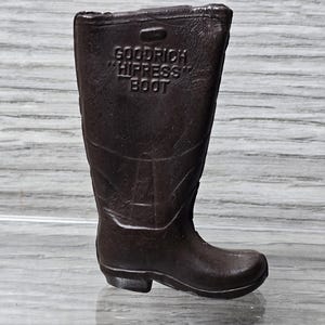 May include: A brown rubber rain boot with the text "GOODRICH HIPRESS BOOT" embossed on the side.
