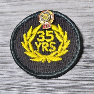 Zestaw vintage'owych przypinek i naszywek z nagrodą za 35-letni staż weteranów wojen zagranicznych VFW