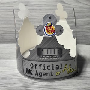 May include: A gray and white paper crown with the Burger King Big Kids logo and the text "MIIB Men in Black II Now in Theaters." The crown reads "Official BK Agent or Alien."