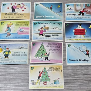 Puede incluir: Una colección de tarjetas de felicitación navideñas vintage con ilustraciones coloridas. Las tarjetas presentan escenas invernales, nieve y figuras de dibujos animados. El texto incluye "Season's Greetings" y "Holiday Greetings."