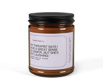 May include: A brown glass candle jar with a black lid. The label reads "Semarak Muda Co." and features the text "My therapist says I have a great sense of humour... but she's not laughing."  The text continues "Brighter than the average person's future."