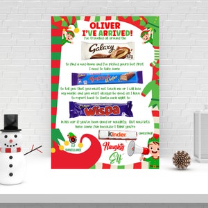 Pode incluir: Um cartão de Natal imprimível com um personagem de duende e o texto "Oliver I've Arrived!" O cartão apresenta uma lista de barras de chocolate, incluindo Galaxy, Time Out, Wispa e Kinder, com uma mensagem sobre ser bom ou mau.
