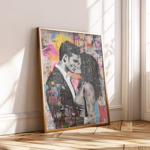 Puede incluir: Obra de arte enmarcada que presenta una imagen en escala de grises de una pareja besándose, sobre un fondo vibrante de estilo grafiti con salpicaduras de rosa, amarillo y azul. El marco dorado añade un toque de elegancia a la pieza de arte moderno.