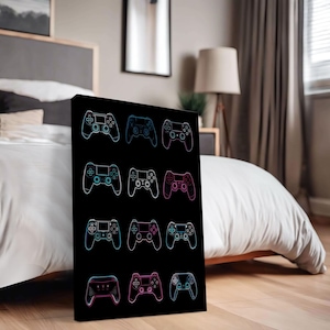 Op de afbeelding: Zwart canvas kunstwerk met een raster van twaalf neon-omlijnde gamecontrollers. De controllers zijn in blauw, roze en paars, met een zwarte achtergrond. Het kunstwerk wordt in een slaapkamer getoond.