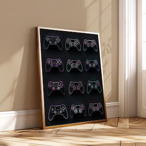 May include: Framed artwork featuring a grid of twelve game controllers in a neon outline style. The controllers are in various colors, including purple, pink, and green, set against a black background. The frame is gold, and the artwork is leaning against a wall.