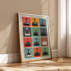 May include: Framed art print featuring a grid of twelve retro-style joysticks. Each joystick is set against a different colored background, including red, blue, and green. The joysticks have black bases and various colored tops.