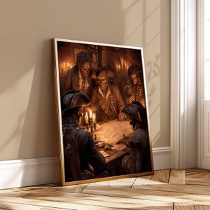 May include: A framed artwork depicts a gathering of skeletal pirates around a table, illuminated by candlelight. The pirates wear tricorn hats and period clothing, with a map spread before them. The artwork has a gold frame and is leaning against a wall.