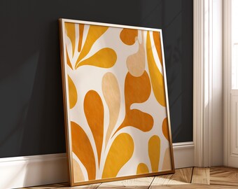 Può includere: Una stampa artistica incorniciata con un design astratto di forme organiche arancioni e gialle su sfondo crema. L'opera d'arte è in una cornice dorata e poggia su un muro grigio scuro.